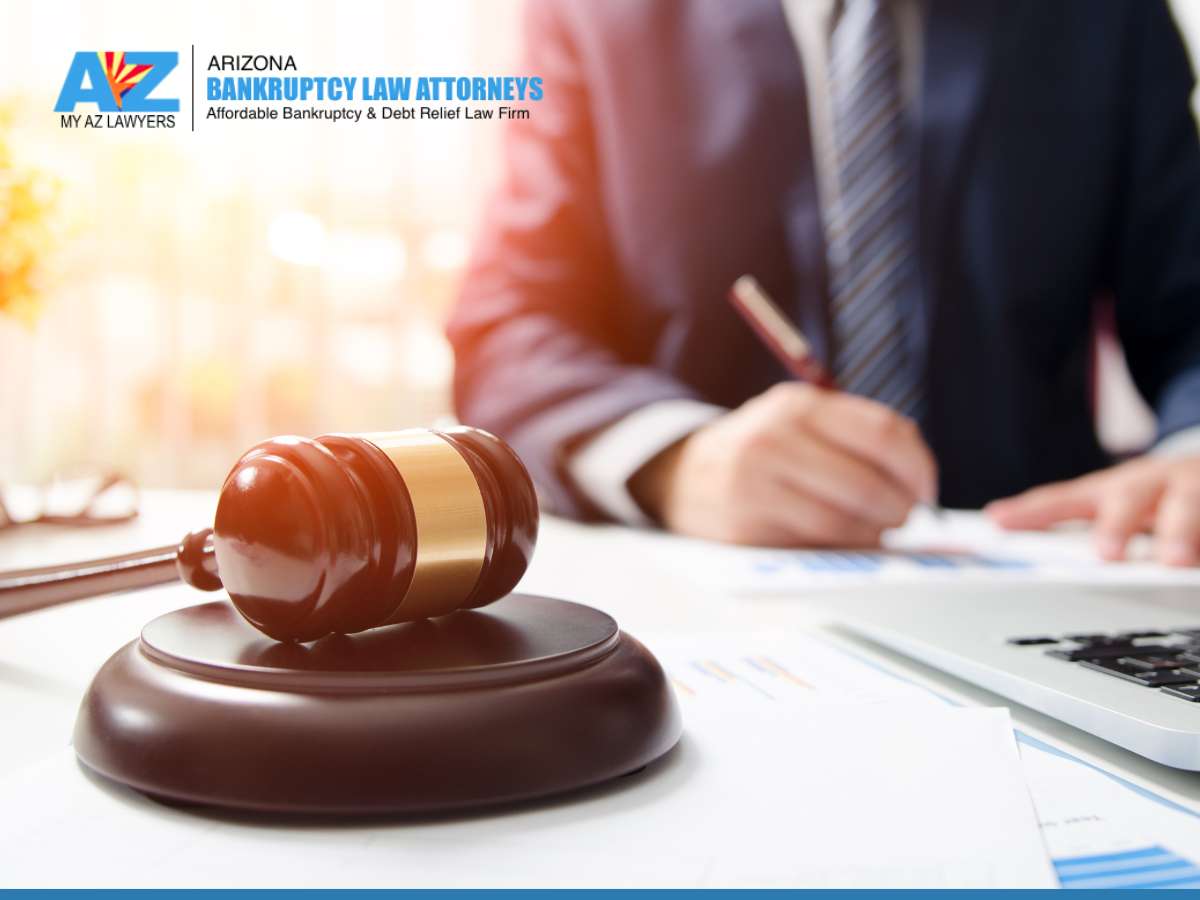 An image featuring a gavel on a desk with a person in a suit working in the background, representing legal proceedings related to bankruptcy fraud.