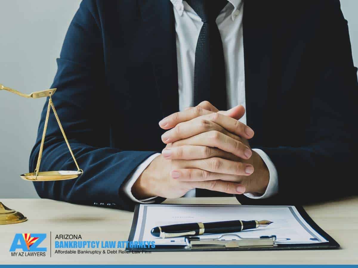 A lawyer discussing documents with a scale of justice, symbolizing Bankruptcy in Arizona.